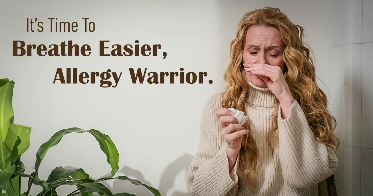 A woman with a tissue, holding her nose, fighting a sneeze.