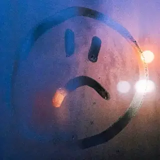 Condensation on a window, and an unhappy face drawn onto it.