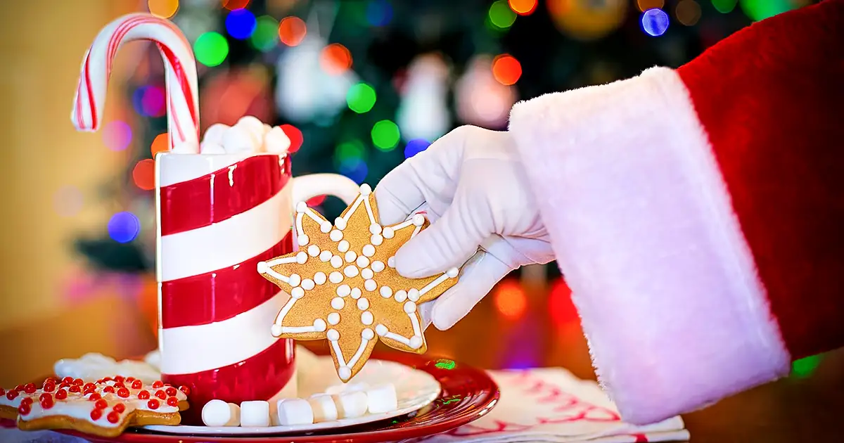 Santa picking up a star shaped cookie.